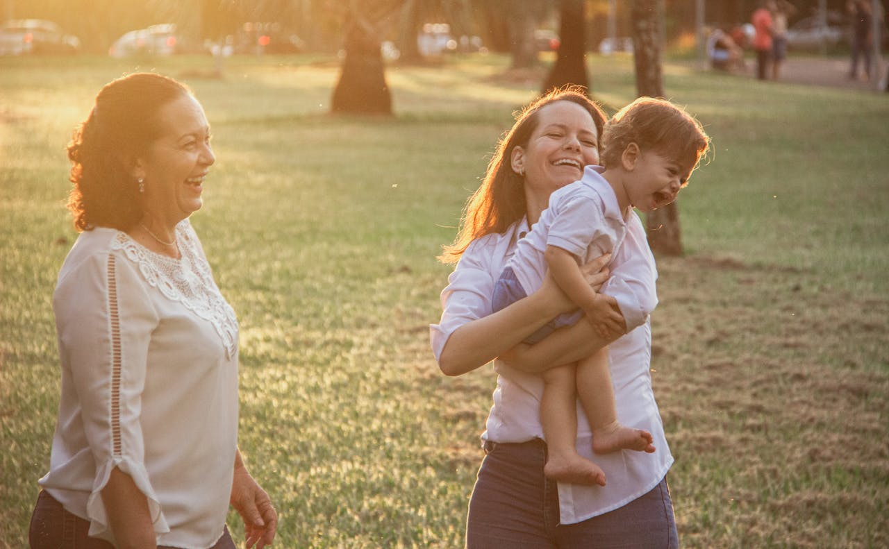 Happy family enjoying a walk in the park during sunset, capturing genuine joy and connection.